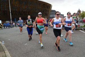 Ros Drake runs past the Wales Millennium Centre in the 2025 Cardiff Half Marathon.
